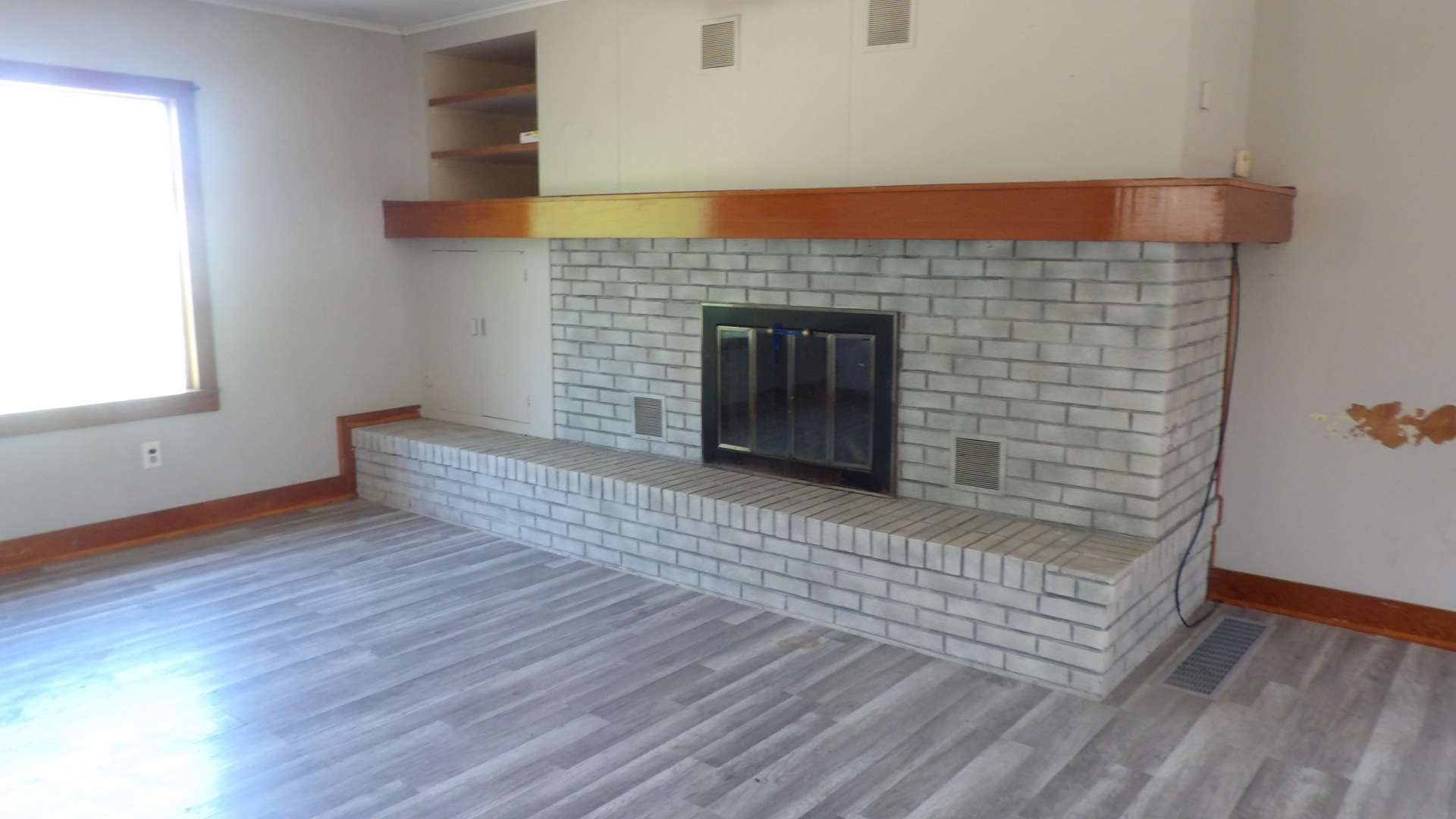 606 Bohn Street Rosiclare, IL 62982 - Photo 2 of 12 an empty room with wooden floor and fireplace