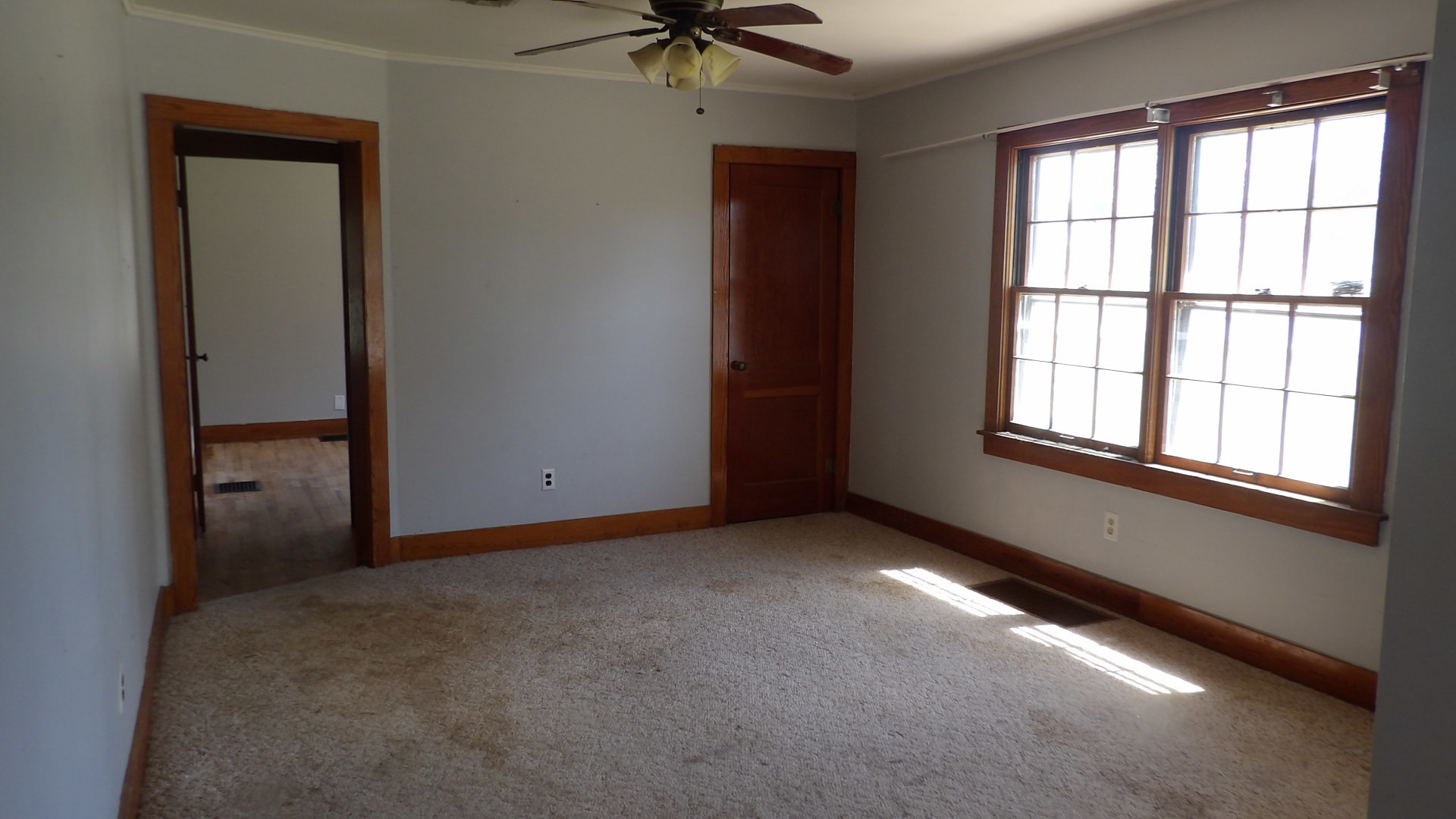 606 Bohn Street Rosiclare, IL 62982 - Photo 3 of 12 an empty room with a window and a ceiling fan