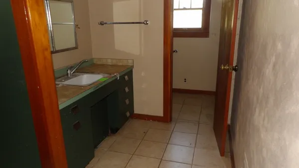 a bathroom with a granite countertop sink a mirror and a shower