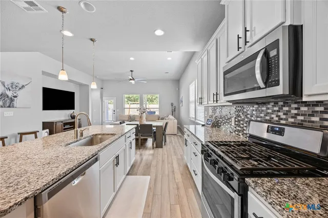 a kitchen with sink stove and microwave