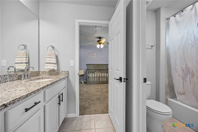 a bathroom with a granite countertop sink a toilet and shower