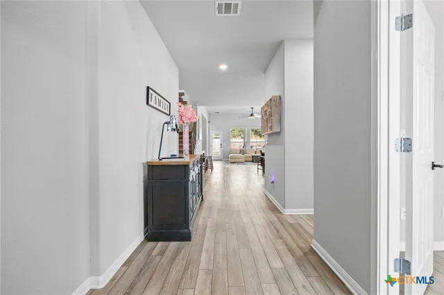 a view of a hallway view with wooden floor and electronic appliances