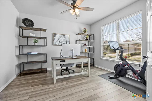 a view of a workspace with furniture and a window