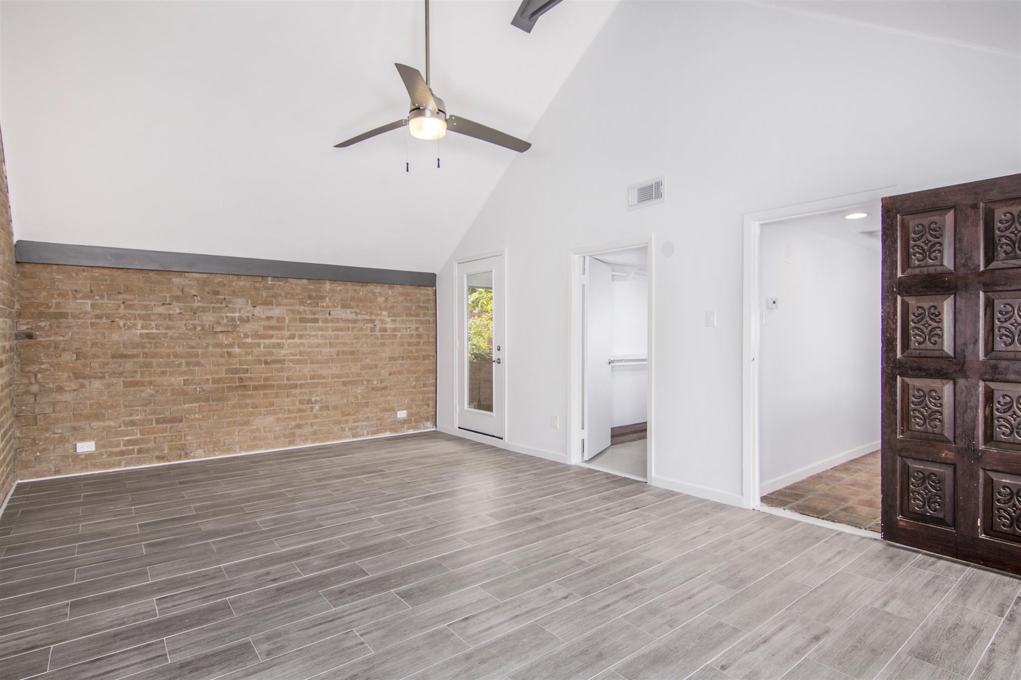 1942 Indiana Street Houston, TX 77019 - Photo 11 of 40 View of the primary bedroom toward the tree-covered balcony, which is accessible through the glass door.