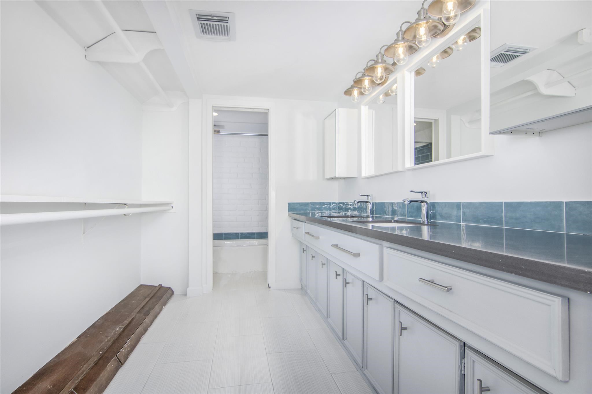 1942 Indiana Street Houston, TX 77019 - Photo 12 of 40 En-suite primary bathroom with quartz counters, double sinks, updated plumbing, fixtures, lighting and plenty of storage.
