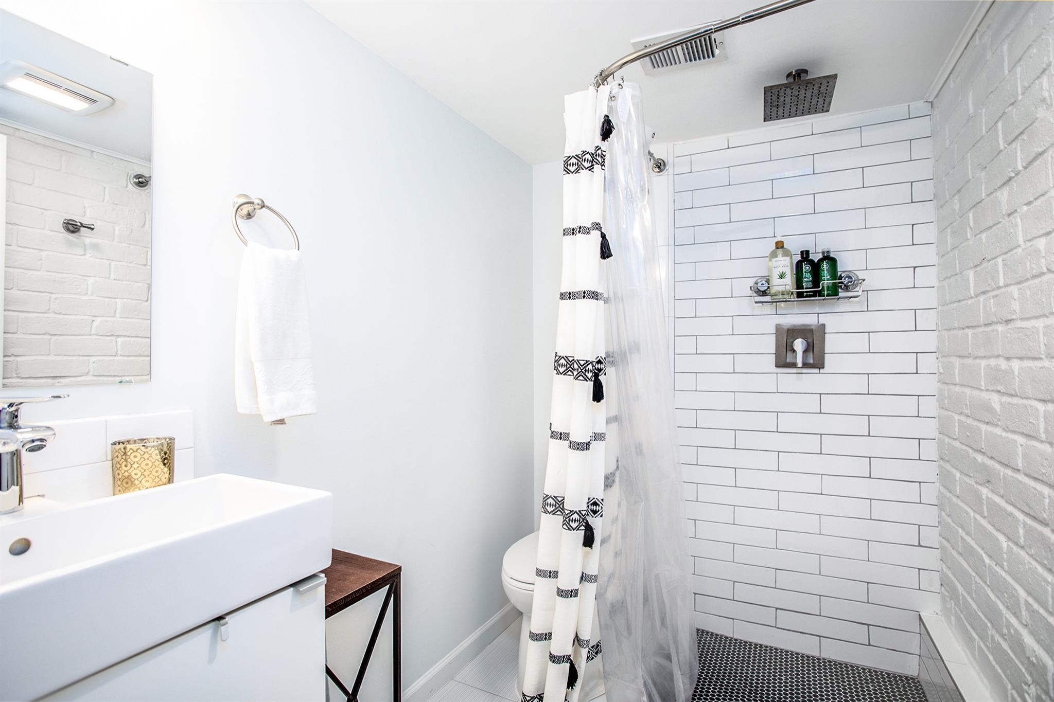 1942 Indiana Street Houston, TX 77019 - Photo 15 of 40 En-suite secondary bath offers a rainfall showerhead and recently updated plumbing and fixtures.