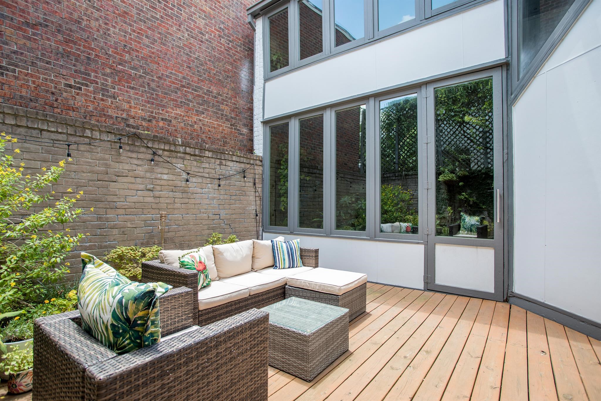 1942 Indiana Street Houston, TX 77019 - Photo 18 of 40 a view of a patio with couches and floor to ceiling window with wooden floor