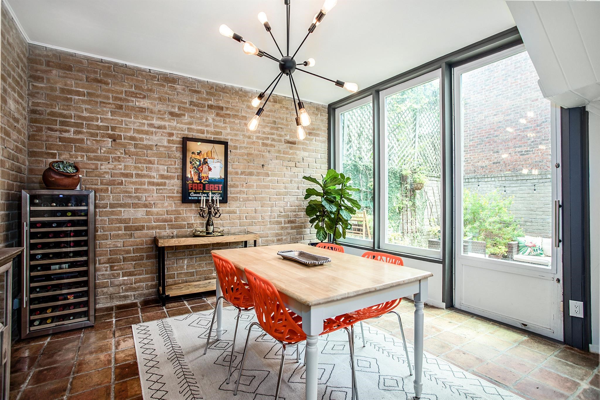 1942 Indiana Street Houston, TX 77019 - Photo 9 of 40 Cozy and bright dining room surrounded by exposed brick walls and oversized windows. The glass door on the right leads to the backyard.