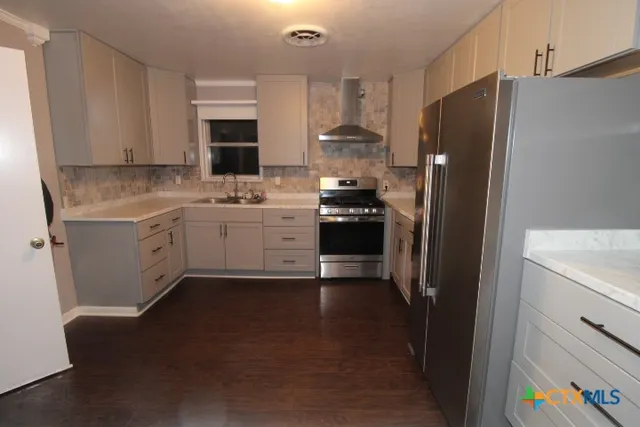 a kitchen with stainless steel appliances a stove refrigerator sink and microwave