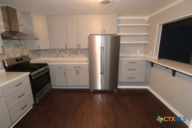 a kitchen with a refrigerator stove and white cabinets
