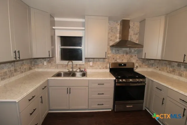 a kitchen with white cabinets and appliances