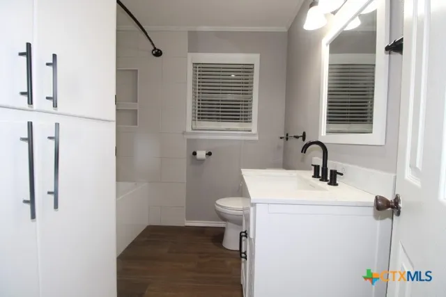 a bathroom with a sink a toilet and a mirror