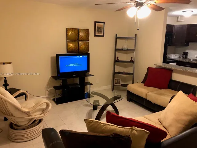 a living room with furniture a flat screen tv and lamp