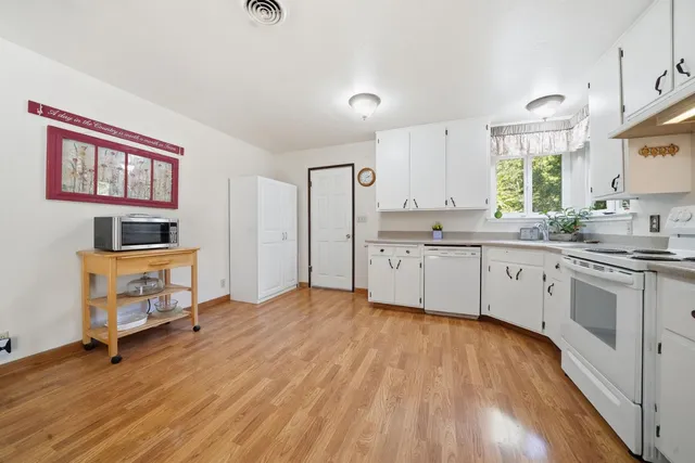 a kitchen with stainless steel appliances a stove top oven a sink dishwasher and a microwave oven with cabinets