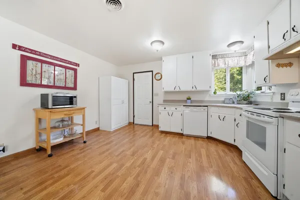 a kitchen with stainless steel appliances a stove top oven a sink dishwasher and a microwave oven with cabinets