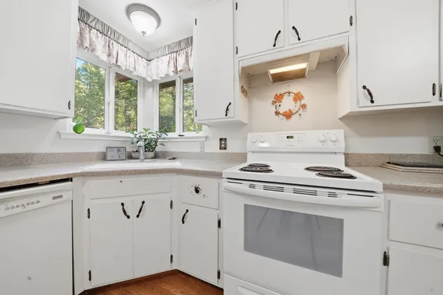 a kitchen with cabinets appliances and a large window