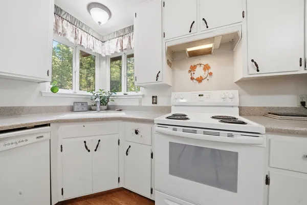 a kitchen with cabinets appliances and a large window