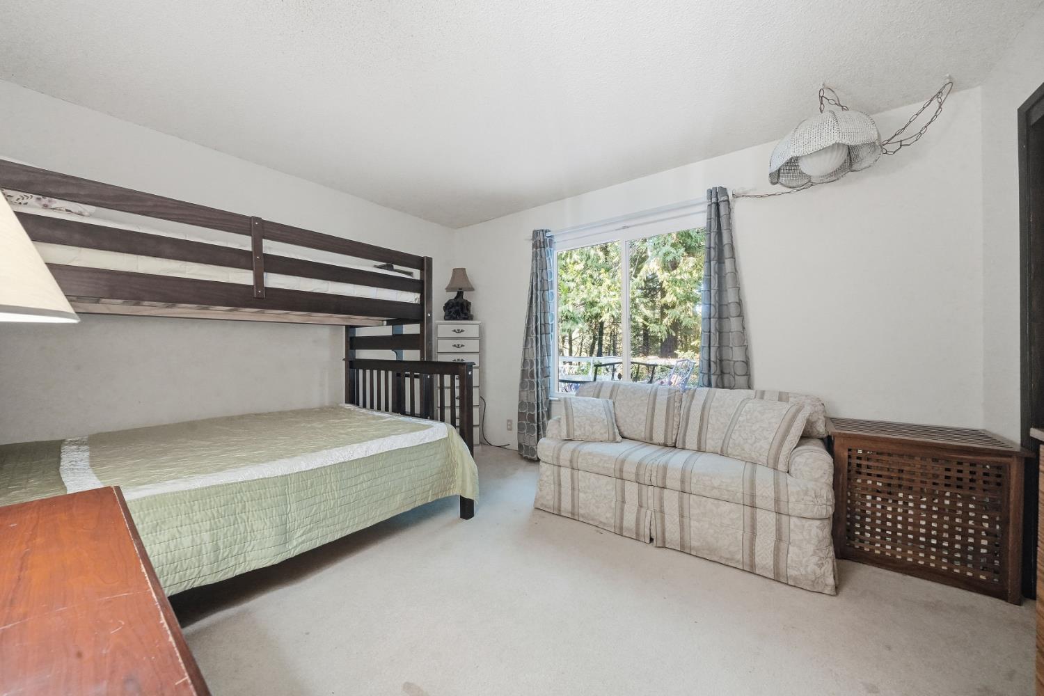 23420 Robin Road Pioneer, CA 95666 - Photo 30 of 43 a bedroom with a bed couch and window