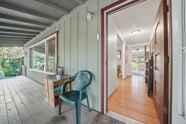 a view of a hallway with wooden floor and furniture