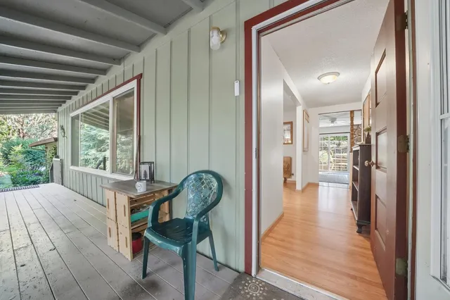 a view of a hallway with wooden floor and furniture