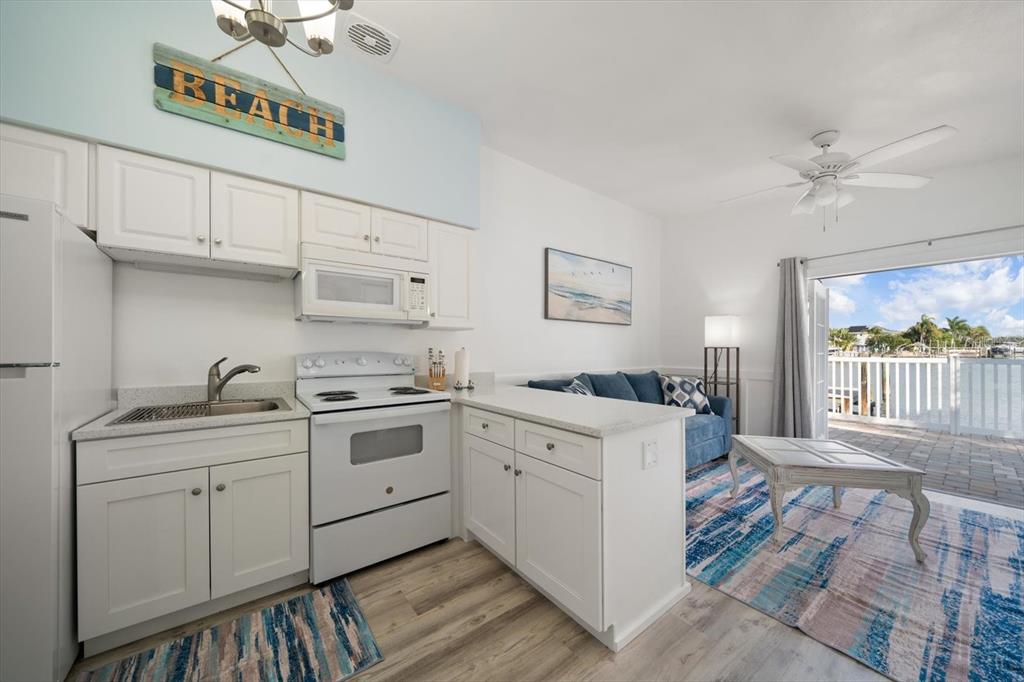 711 East Gulf Boulevard Indian Rocks Beach, FL 33785 - Photo 21 of 35 a kitchen with a stove a sink and a refrigerator