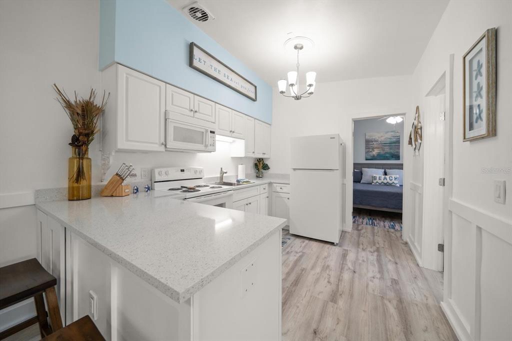 711 East Gulf Boulevard Indian Rocks Beach, FL 33785 - Photo 9 of 35 a kitchen with stainless steel appliances a refrigerator sink and cabinets