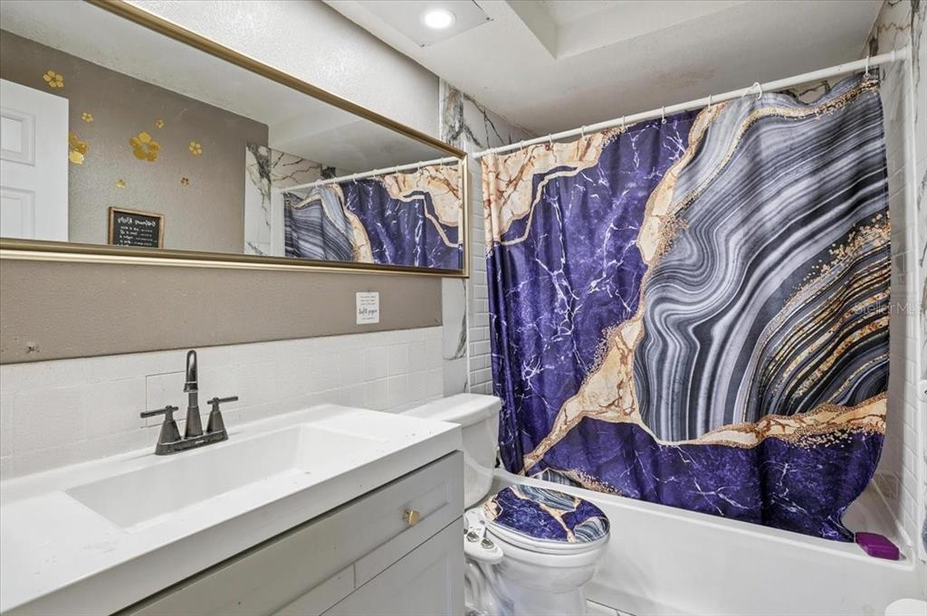 3208 Kilburn Road Holiday, FL 34691 - Photo 15 of 17 a bathroom with a sink and mirror with toilet