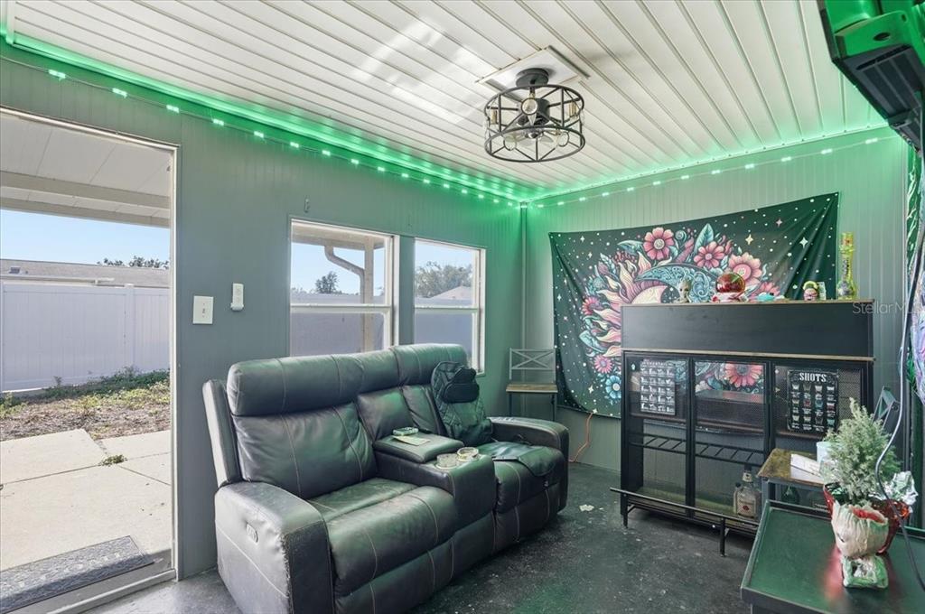 3208 Kilburn Road Holiday, FL 34691 - Photo 16 of 17 a living room with furniture a fireplace and a chandelier