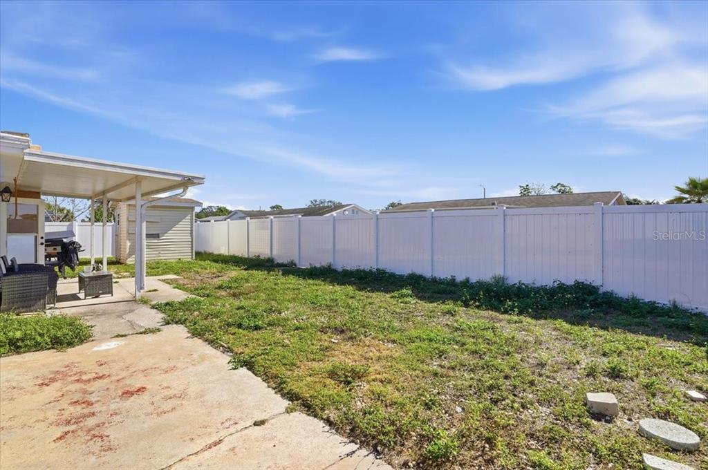 3208 Kilburn Road Holiday, FL 34691 - Photo 17 of 17 a view of a backyard with potted plants and large tree