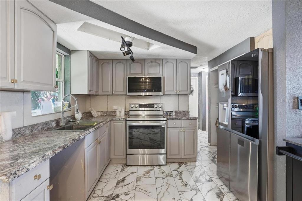 3208 Kilburn Road Holiday, FL 34691 - Photo 5 of 17 a kitchen with granite countertop a refrigerator and a sink