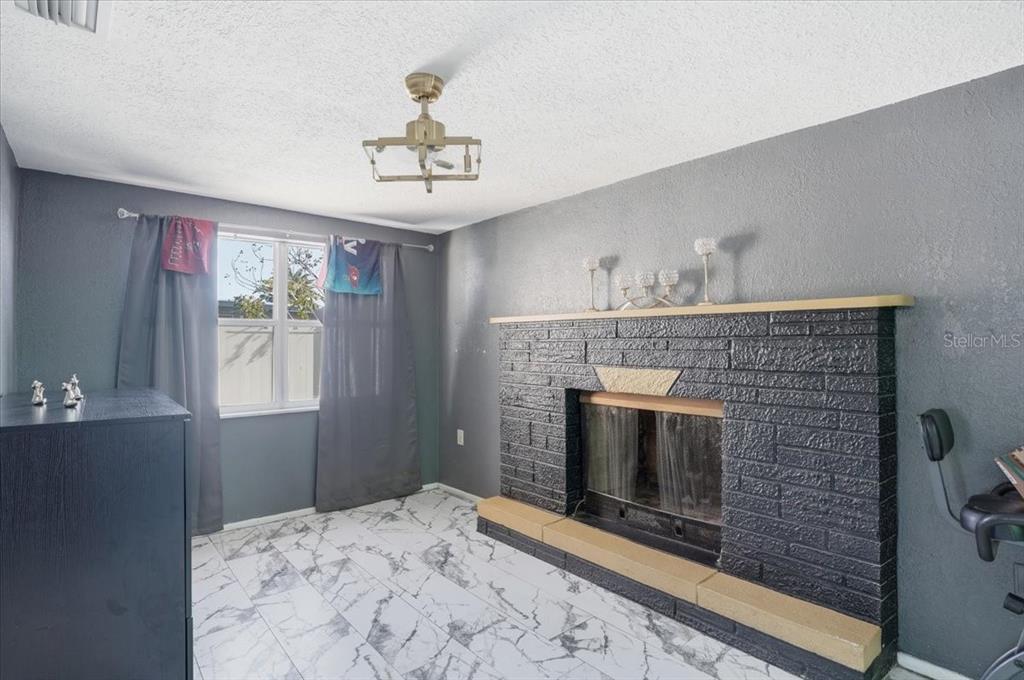 3208 Kilburn Road Holiday, FL 34691 - Photo 9 of 17 a view of an empty room with a fireplace and a window