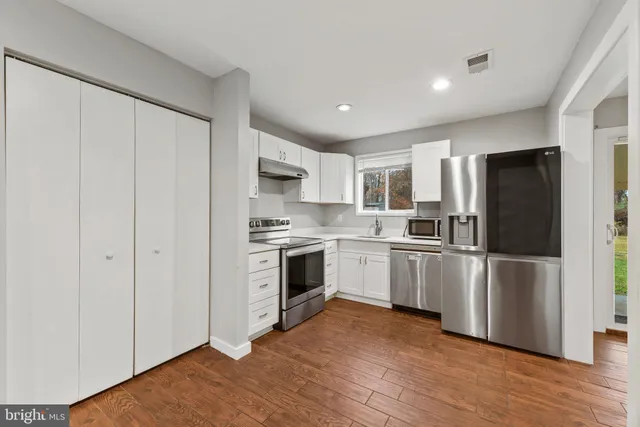a kitchen with a refrigerator stove and white cabinets