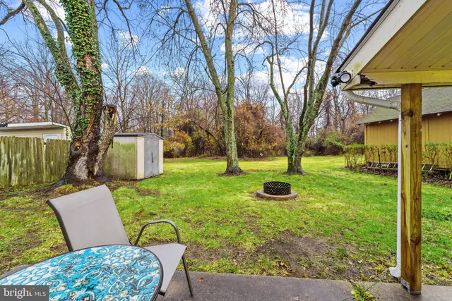 a backyard of a house with table and chairs