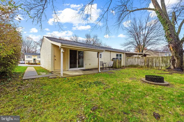 a view of a house with backyard and a tree