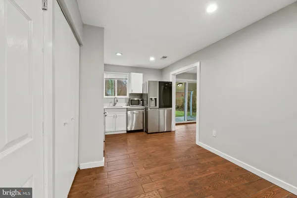 a view of a kitchen with a sink and dishwasher a refrigerator with wooden floor