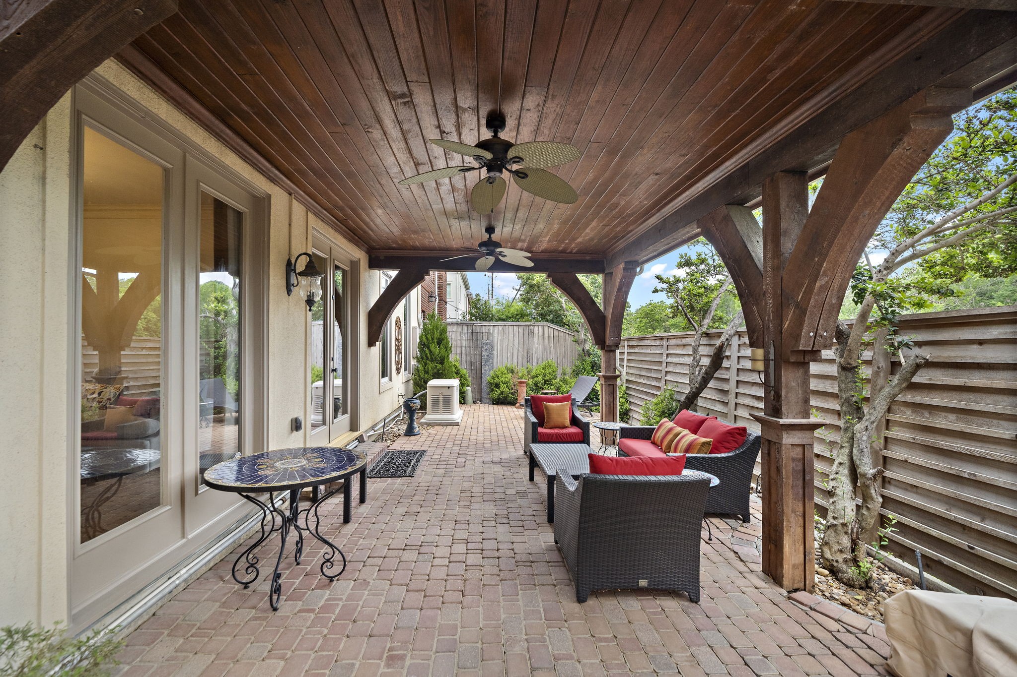 1229 Ripple Creek Drive Houston, TX 77057 - Photo 31 of 49 This photo shows a compact laundry room with modern appliances, including a front-loading washer and dryer. It features ample storage with overhead cabinets and a counter for folding. The space is efficiently organized, with a vacuum mounted on the wall and a hanging rod for clothes.