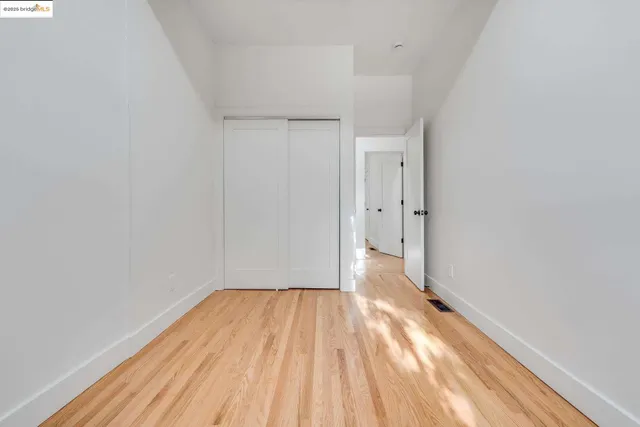 a view of room with wooden floor and white walls