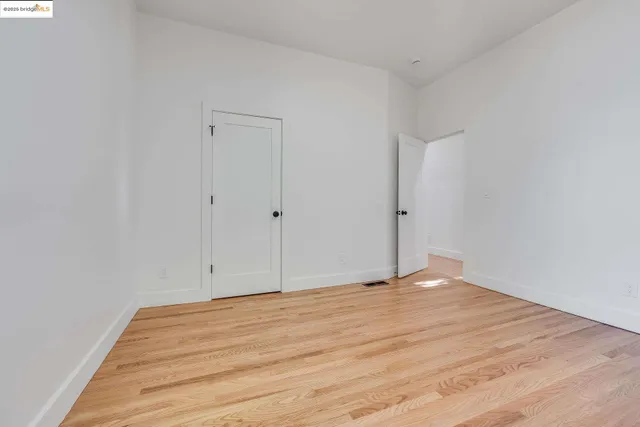 a view of a big room with wooden floor and a window