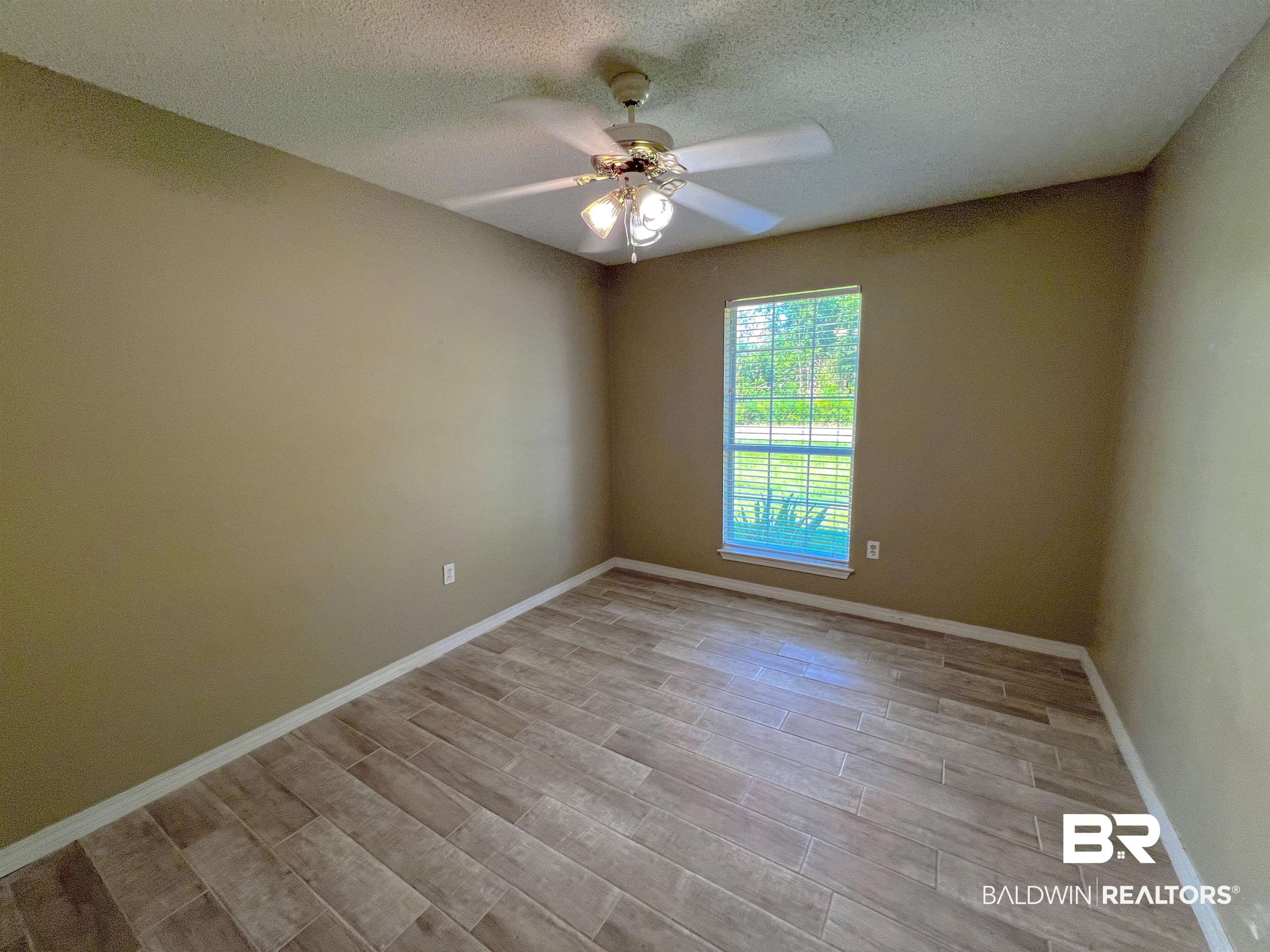 1200 South Juniper Street Foley, AL 36535 - Photo 10 of 23 Empty room featuring a textured ceiling and ceiling fan