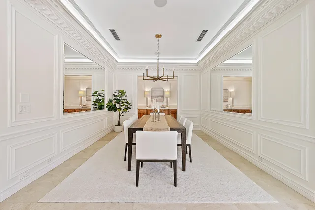 a dining room with wooden floor and a chandelier