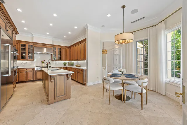 a kitchen with stainless steel appliances kitchen island granite countertop a sink and a refrigerator