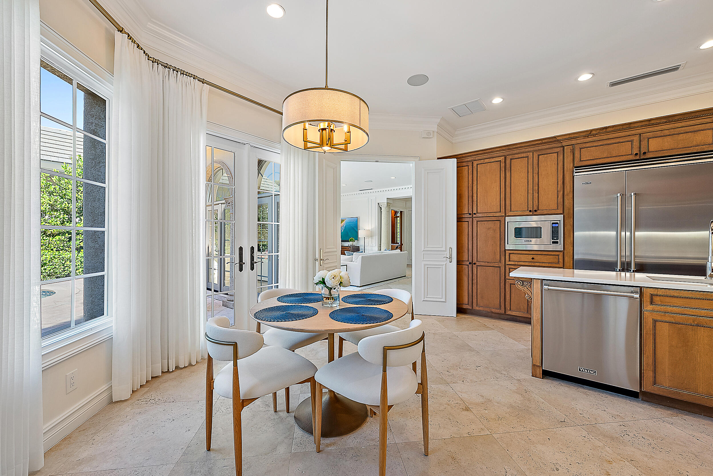 314 Chilean Avenue Palm Beach, FL 33480 - Photo 15 of 46 a kitchen with stainless steel appliances kitchen island granite countertop a table and chairs in it
