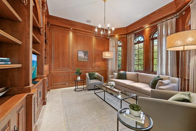 a living room with furniture a chandelier and a window