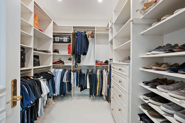 a view of walk in closet with clothes and shoes