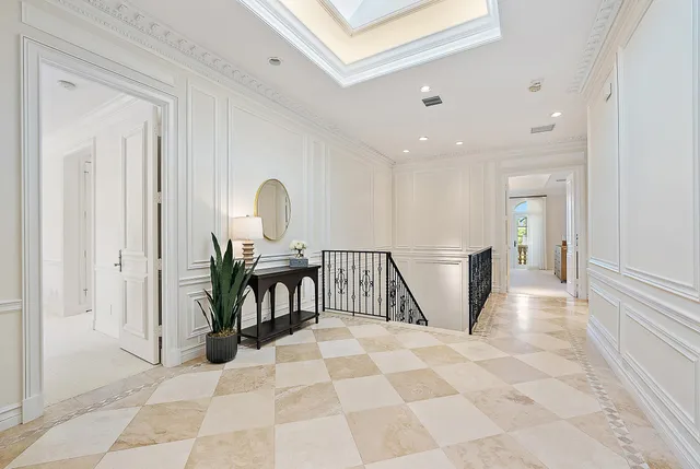 a view of a hallway with a couch and chandelier
