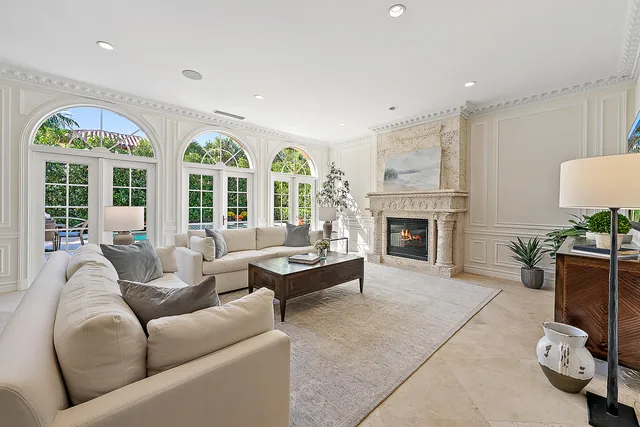 a living room with furniture a fireplace and a floor to ceiling window