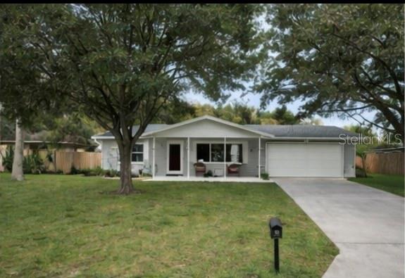 2352 Lorena Lane Clearwater, FL 33765 - Photo 3 of 5 a front view of a house with a garden and trees