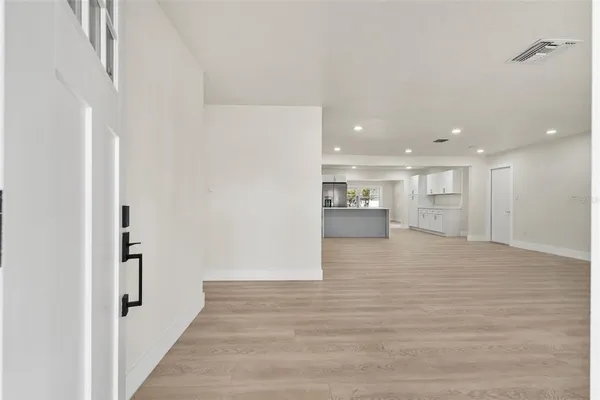 a view of a big room with wooden floor and windows