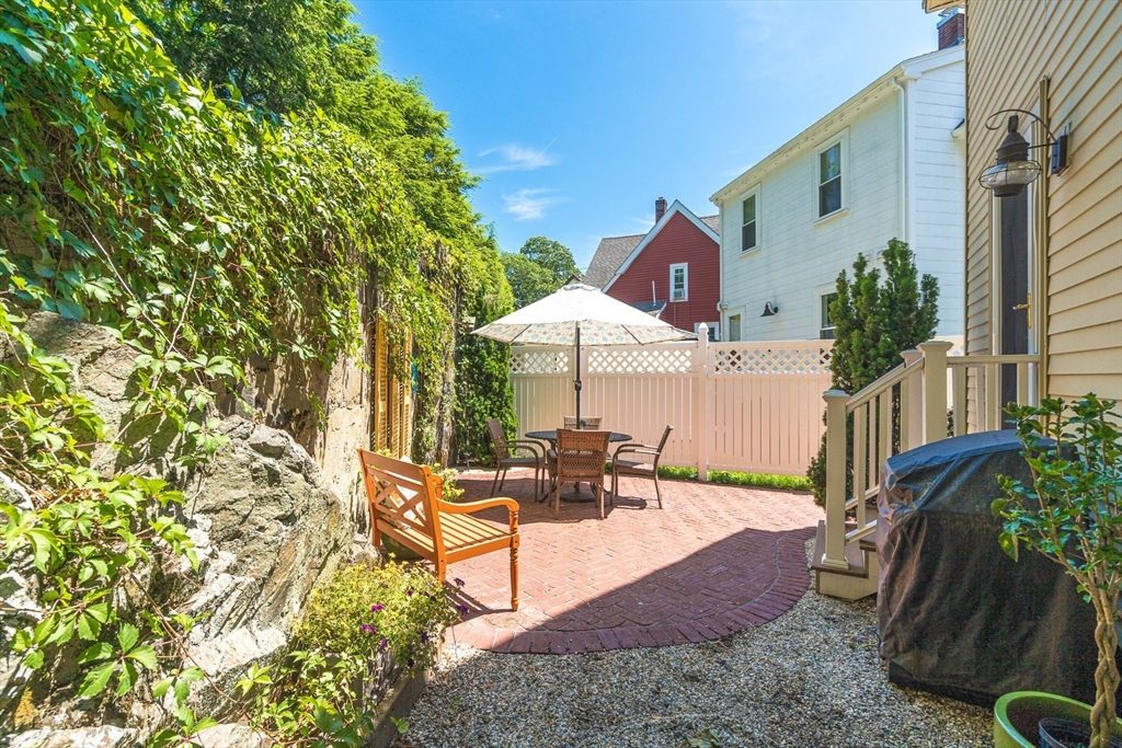 15 Maple Street Melrose, MA 02176 - Photo 32 of 38 a view of a patio with table and chairs with wooden fence and plants