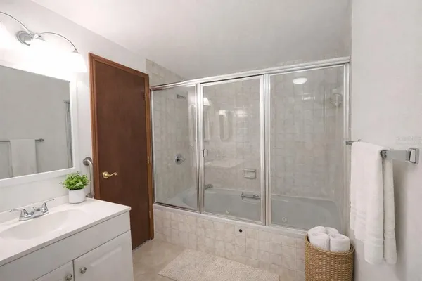 a bathroom with a shower a sink a toilet and mirror
